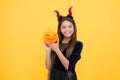 Happy witch teenage devil girl wear imp horns costume on halloween party and hold pumpkin jack o lantern, halloween mood Royalty Free Stock Photo