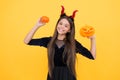 Happy witch teenage devil girl wear imp horns costume on halloween party and hold pumpkin jack o lantern, halloween Royalty Free Stock Photo