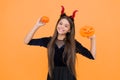 happy witch teenage devil girl wear imp horns costume on halloween party and hold pumpkin jack o lantern, halloween Royalty Free Stock Photo