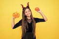 happy witch teenage devil girl wear imp horns costume on halloween party and hold pumpkin jack o lantern, halloween Royalty Free Stock Photo