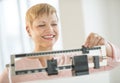 Happy Woman Adjusting Balance Weight Scale Royalty Free Stock Photo
