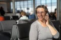Happy woman at an airport waiting for flight Royalty Free Stock Photo