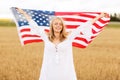 Happy woman with american flag on cereal field