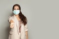 Happy woman in anti virus protection mask to prevent others from corona COVID-19 holding thumb up on gray banner background Royalty Free Stock Photo