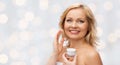 Happy woman applying cream to her face Royalty Free Stock Photo