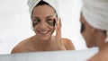 Happy woman applying gel patches for treatment under eye bags Royalty Free Stock Photo