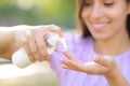 Happy woman applying hydration cream on finger