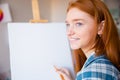 Happy woman artist making sketches on canvas in art class