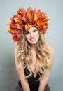 Happy woman in autumn leaves crown. Perfect model girl with makeup and blonde curly hairstyle Royalty Free Stock Photo