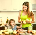 Happy woman with baby cooking with potatoes