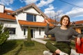 Happy woman on the background of a new house. Portrait of first time buyer, house owner, apartment renter, flat tenant Royalty Free Stock Photo