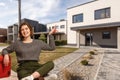 Happy woman on the background of a new house. Portrait of first time buyer, house owner, apartment renter, flat tenant Royalty Free Stock Photo