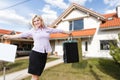 Happy woman on the background of a new house. Portrait of first time buyer, house owner, apartment renter, flat tenant Royalty Free Stock Photo