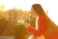 Happy woman in a balcony looks away drinking coffee Royalty Free Stock Photo