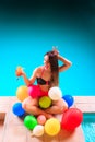 Happy woman with balloons and cocktail at poolside Royalty Free Stock Photo