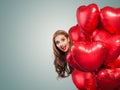 Happy woman with balloons red heart on white background with copy space. Surprised girl with red lips makeup on big banner card. Royalty Free Stock Photo