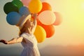 Happy woman with balloons at sunset in summer Royalty Free Stock Photo