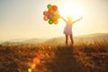 Happy woman with balloons at sunset in summer Royalty Free Stock Photo