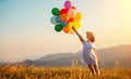 Happy woman with balloons at sunset in summer Royalty Free Stock Photo