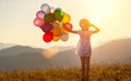 Happy woman with balloons at sunset in summer Royalty Free Stock Photo