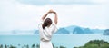 Happy woman in bathrobe stretching after waking up and enjoy Ocean view, Tourist relaxing in tropical resort. summer travel, Royalty Free Stock Photo