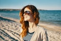 happy woman on the beach near the sea in the mountains glasses on the face red hair model landscape Royalty Free Stock Photo