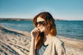 happy woman on the beach near the sea in the mountains glasses on the face red hair model landscape Royalty Free Stock Photo