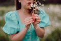 Happy woman beautiful blowing on dandelion in park. Girl in vintage blue dress. Wishing, joy concept. Springtime Royalty Free Stock Photo