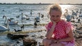 Happy girl in a beautiful dress young with beautiful eyes on the background of birds of swans on the lake during the day