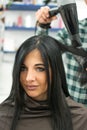 Happy woman at the beauty salon getting a hair cut.