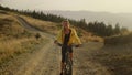 Woman on bicycle riding on path. Female bicyclist exercising in landscape