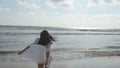 Happy woman in bikini and shirt walking on the beach at the ocean water. Young beautiful girl enjoying life and having Royalty Free Stock Photo