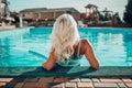Happy woman in bikini sitting near swimming pool, summer vacation. Royalty Free Stock Photo