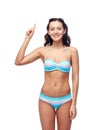 Happy woman in bikini swimsuit pointing finger up Royalty Free Stock Photo