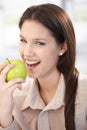 Happy woman biting an apple smiling