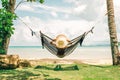 Happy woman in black bikini relaxing in hammock