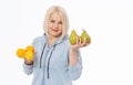 Happy woman with blond hair and beautiful smile holds two oranges, lemon and a pears in her hands for a healthy diet with