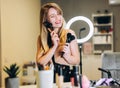 Happy woman with blond hair holds many makeup brushes in her hands. Blonde laughing with makeup brushes near the face Royalty Free Stock Photo