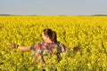 Happy woman on blooming rapeseed field in spring Royalty Free Stock Photo