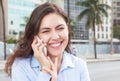 Happy woman in a blue blouse at phone in the city Royalty Free Stock Photo