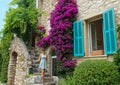 Happy woman in a blue dress poses by an old stone house in the French Riviera. Royalty Free Stock Photo