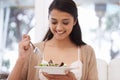 Happy woman, bowl and eating salad for diet, healthy snack or natural nutrition on sofa in living room at home. Female Royalty Free Stock Photo