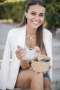 Happy woman with bowl fitness food salmon and vegetables, caucasian woman outdoor