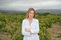 Happy woman with brackets looking at camera in a vineyard on a windy day Royalty Free Stock Photo