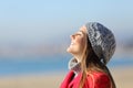 Happy woman breathing deeply fresh air on the beach in winter Royalty Free Stock Photo