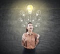 Happy woman in brown near light bulb on blackboard Royalty Free Stock Photo