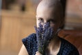 Happy woman with cancer holding bunch of flowers at face Royalty Free Stock Photo