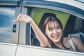 Happy woman with car key sitting and smiling in modern auto outdoors on sunny day. Woman driver holding car keys driving her new Royalty Free Stock Photo