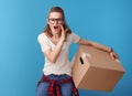 Happy woman with cardboard box telling exciting news on blue Royalty Free Stock Photo