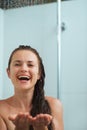 Happy woman catching water drops in shower